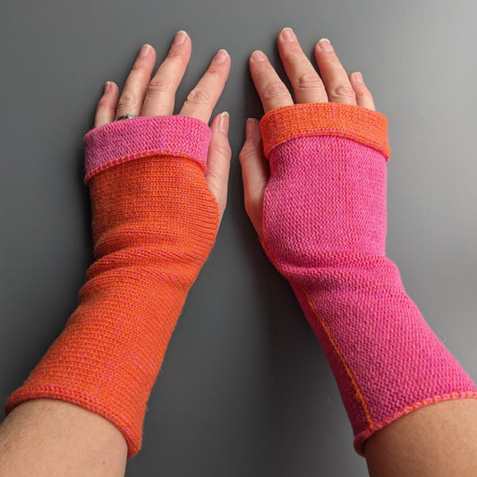 Knitted lambswool reversible wrist warmers in orange and bubblegum pink